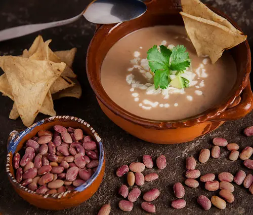 Crema de Frijol con aguacate, crema, queso y totopos